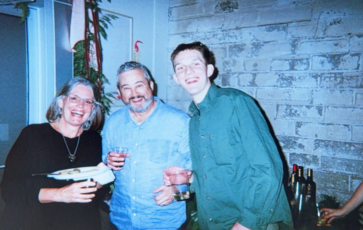Three friends smiling together, drinks in hand